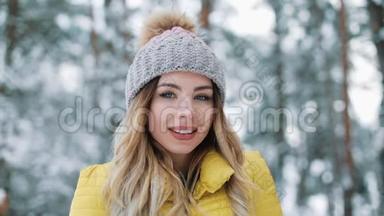 一位迷人的年轻女子看着镜头的冬天画像，身穿黄色<strong>羽绒服</strong>的微笑女孩站在镜头前